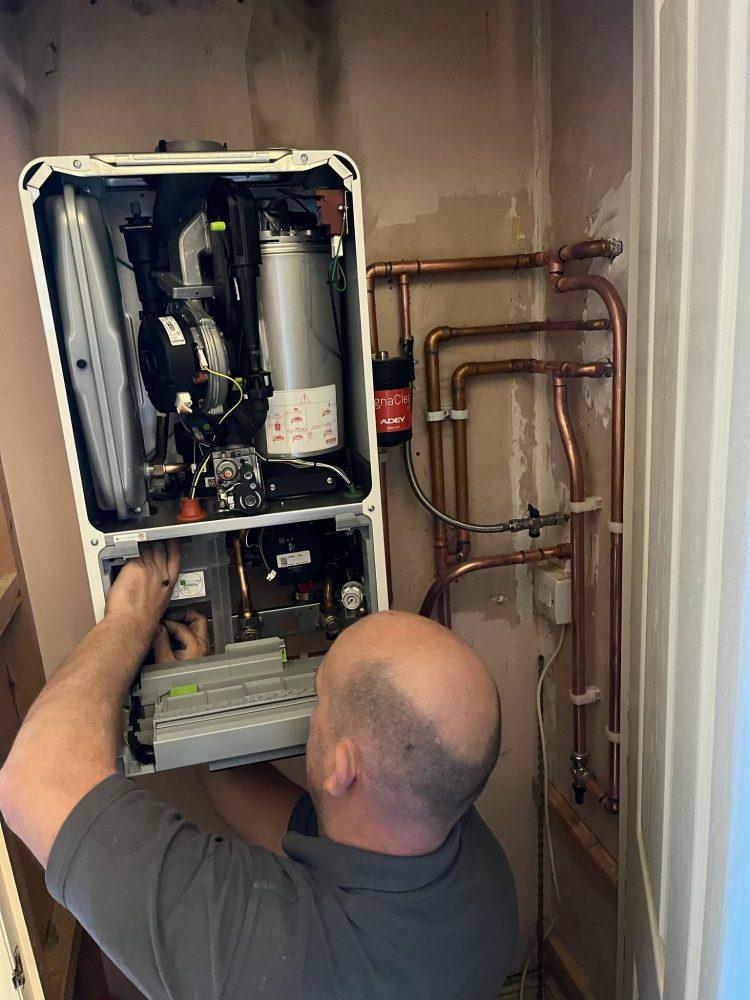 Home Heroes engineer working inside an open boiler casing during a repair