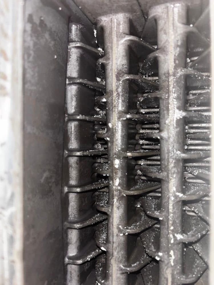 Corroded and sludged heat exchanger fins from a heating system needing a power flush