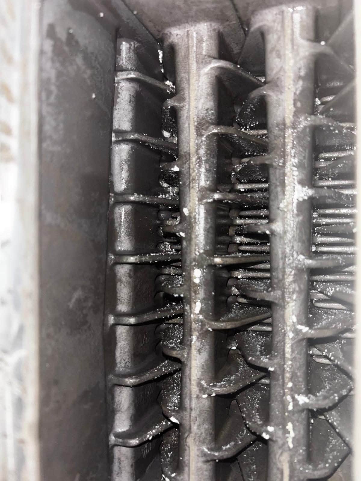 Corroded and sludged heat exchanger fins from a heating system needing a power flush
